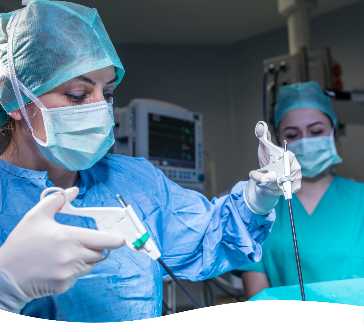 two medical surgeons using surgical devices in operating room