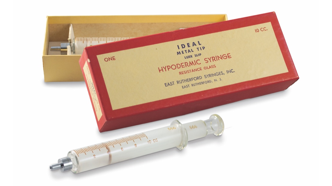 Hypodermic syringe next to box