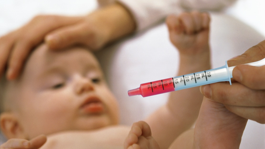 infant being checked on by doctor holding a syringe