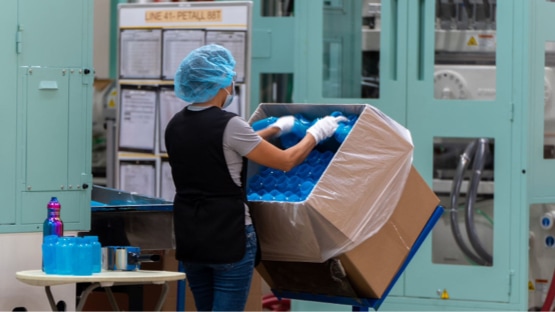 Woman taking blue bottles out of a big box