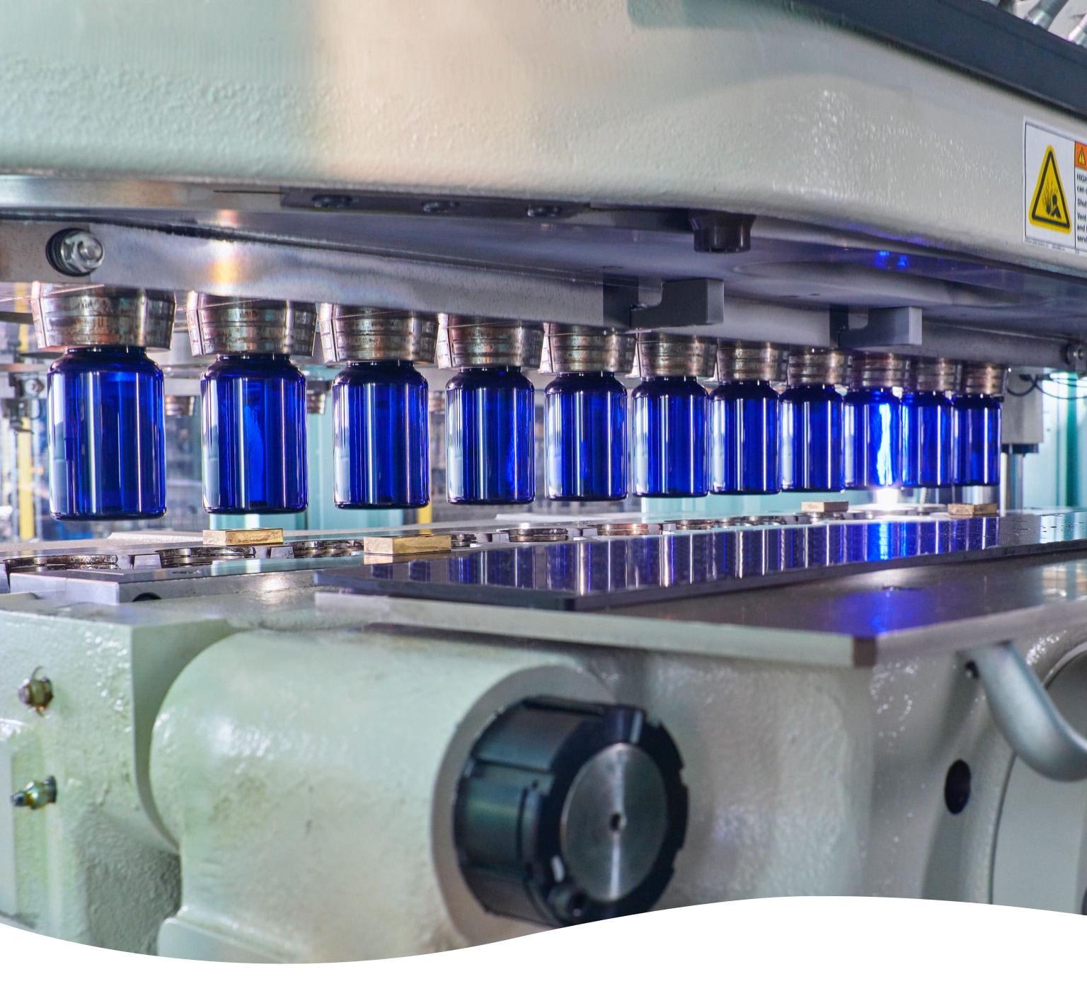 line of plastic blue bottles going through automated machine