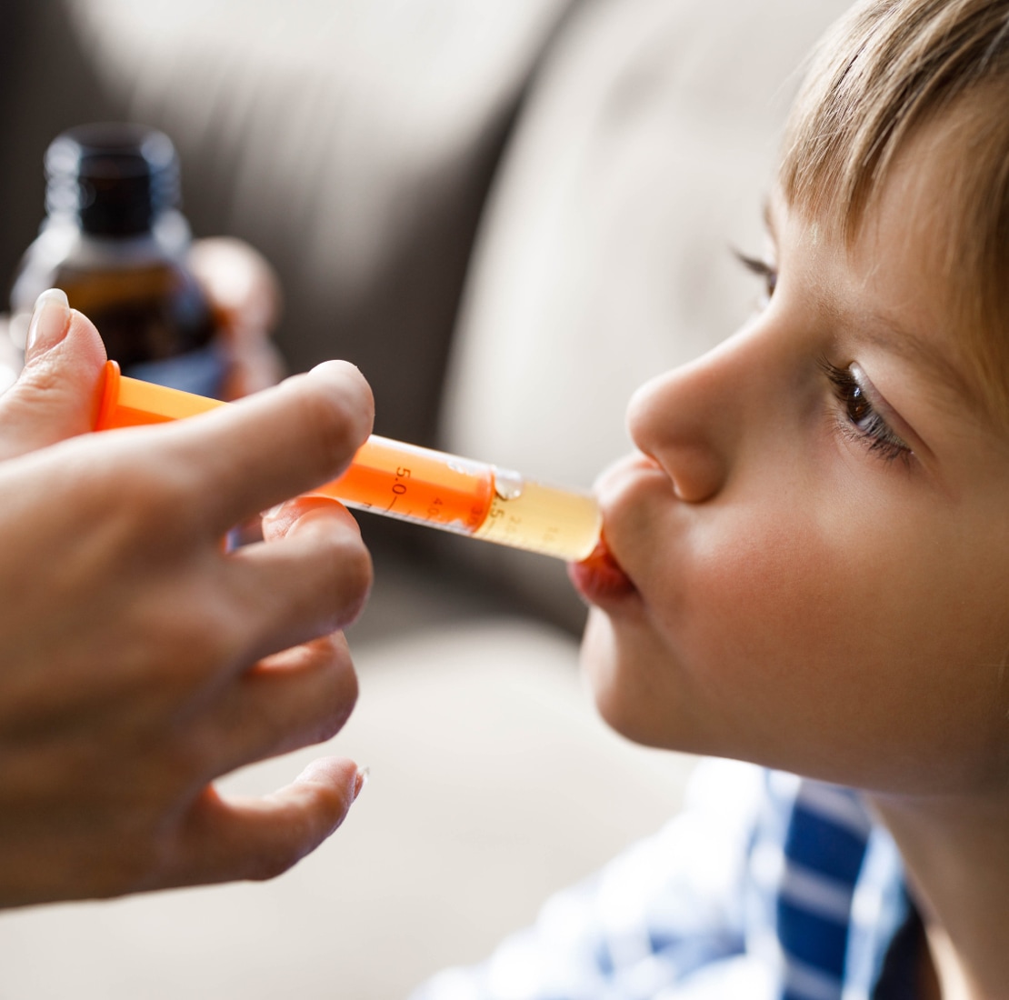 child getting medicine in mouth via syringe